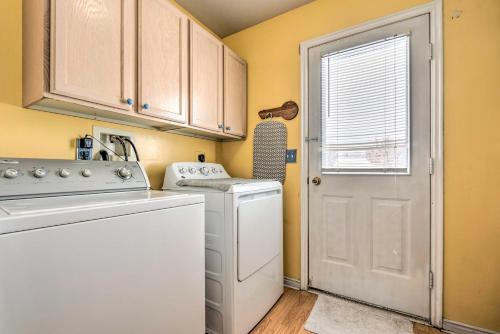 a kitchen with a washer and dryer and a door at Family-Friendly Logan Farmhouse with Yard and Near USU in Logan