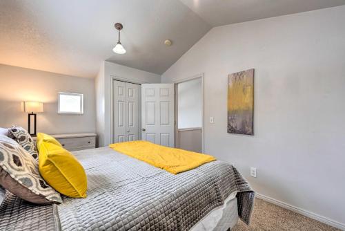 a bedroom with a bed with a yellow blanket at Family-Friendly Logan Farmhouse with Yard and Near USU in Logan