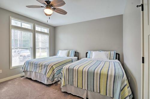a bedroom with two beds and a ceiling fan at Lakefront Cadillac Home with Dock, Fire Pit and Grill! in Cadillac