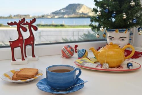 a table with a cup of coffee and a christmas tree at Domus Fortunae B&B in Bacoli