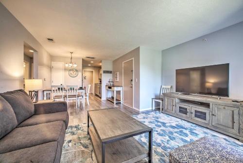 a living room with a couch and a flat screen tv at Cozy Condo with Pool Access in the Heart of Branson! in Branson