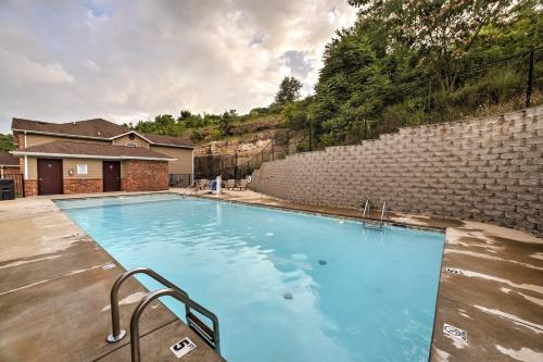 a large blue swimming pool next to a brick wall at Cozy Condo with Pool Access in the Heart of Branson! in Branson