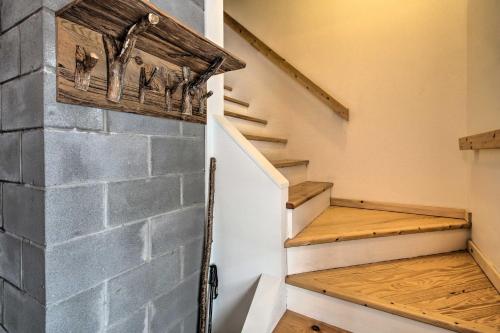 a set of stairs with a stone wall and wood floors at Architect-Designed Franconia Home Hot Tub and Views in Franconia