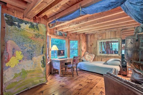 a bedroom with a bed and a desk in a room at The Mill River Cabin with Fireplace and River View! in Mill River