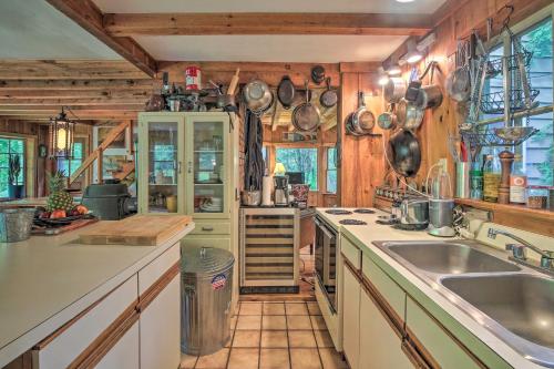 a kitchen with wooden walls and counters and a sink at The Mill River Cabin with Fireplace and River View! in Mill River