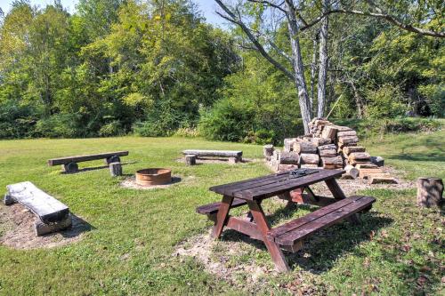 a group of picnic tables and logs in a park at Vintage House with Fire Pit Less Than 6 Mi To Kentucky Lake! in New Concord