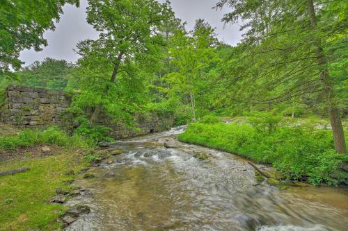 a stream in the middle of a field with trees at The Mill River Cabin with Fireplace and River View! in Mill River