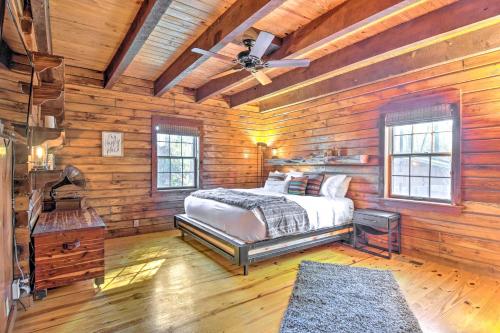 a bedroom with a bed in a wooden cabin at Luxe Cabin with Hot Tub on 5 Acres in Pearcy! in Pearcy