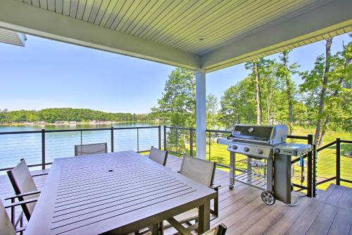 a screened in porch with a grill and a table and chairs at Waterfront Silver Lake Home with Private 40 Dock! in Traverse City