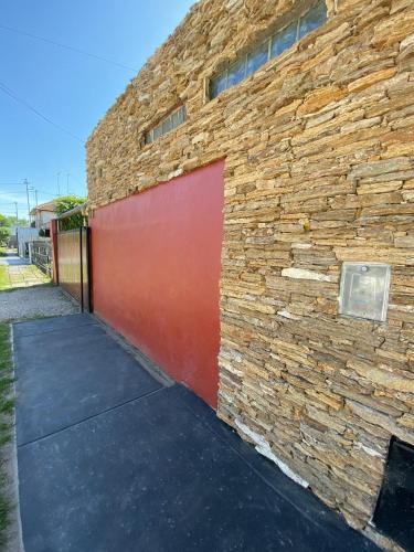 a brick building with a red garage door on it at Casa Confortable in Mar del Plata