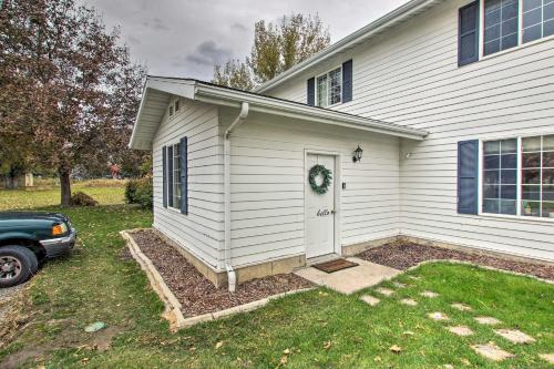 a white house with a door and a car parked in front at North Logan Studio, Walk to Utah State Campus! in Logan
