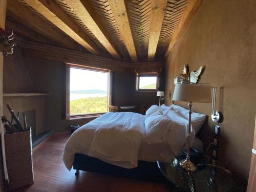 a bedroom with a bed and a large window at Hacienda Ucazanaztacua in Pátzcuaro