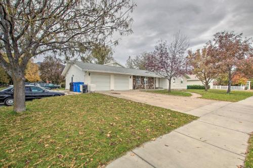 a white house with a car parked in a yard at North Logan Studio, Walk to Utah State Campus! in Logan