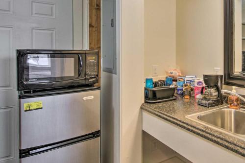 a kitchen with a microwave on top of a refrigerator at North Logan Studio, Walk to Utah State Campus! in Logan