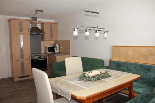 a living room and kitchen with a table and a couch at Haus Heidrun in Fendels