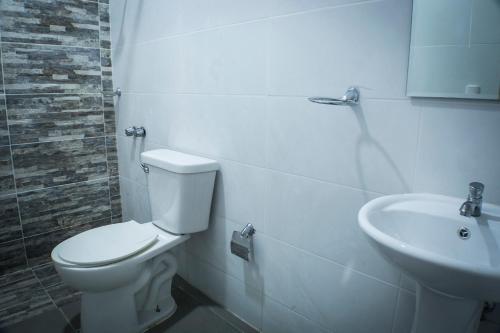a bathroom with a toilet and a sink at Malecon Premium Rooms & Hotel in Santo Domingo