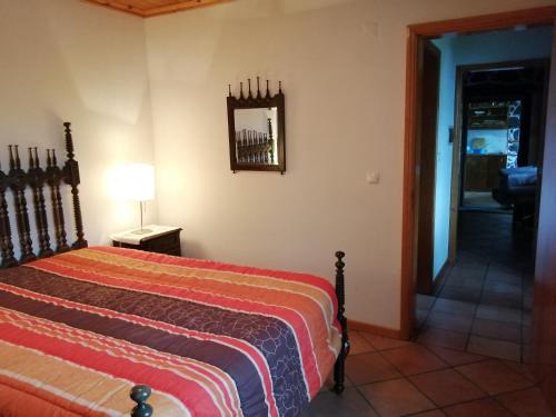 a bedroom with a bed and a mirror on the wall at Casa da Alícia in Feiteira