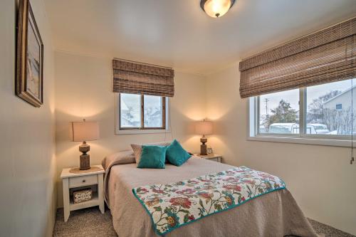 una piccola camera da letto con un letto e due finestre di Hip Downtown Cottage - Walk to Beach, Pier, Dining a East Tawas