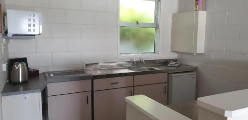 a small kitchen with a sink and a window at Whangaroa Lodge Motel in Whangaroa