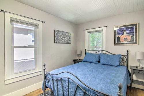 a bedroom with a blue bed and a window at Colorado Springs Bungalow - Walk to Downtown! in Colorado Springs
