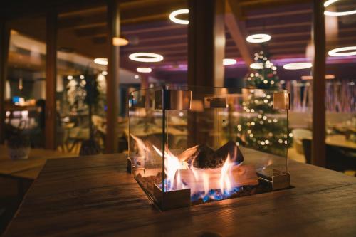a fireplace on a wooden table with a christmas tree at Insel der Sinne in Görlitz