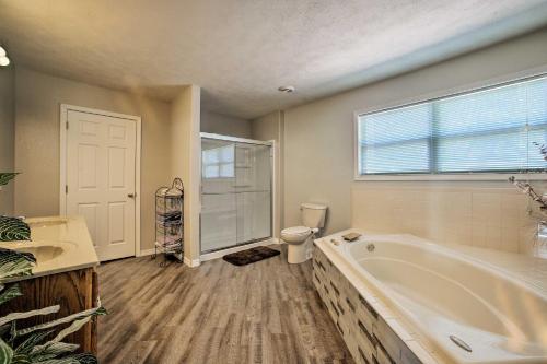 a bathroom with a tub and a toilet and a window at Pet-Friendly, Lakefront Home in Golden with Patio! in Golden
