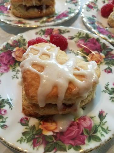 um prato com um pedaço de pastelaria com cobertura de gelo em The Lion and the Rose Bed and Breakfast em Asheville