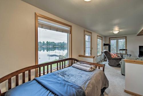 a bedroom with a bed and a large window at Lakefront Home with Seasonal Dock - 2 mi to Skiing! in Wautoma
