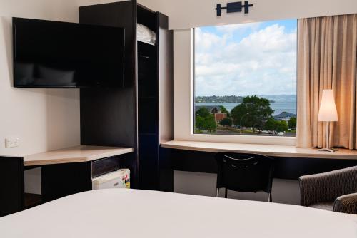 a hotel room with a bed and a large window at ibis Rotorua in Rotorua