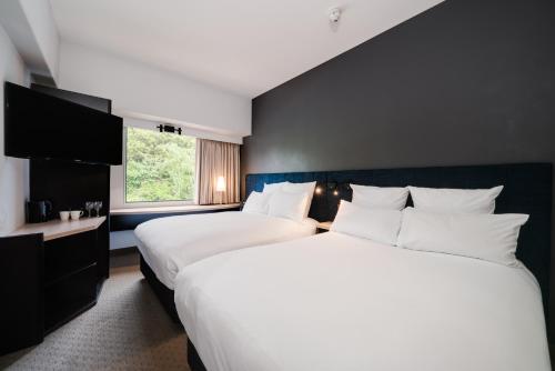 a hotel room with two beds and a window at ibis Rotorua in Rotorua