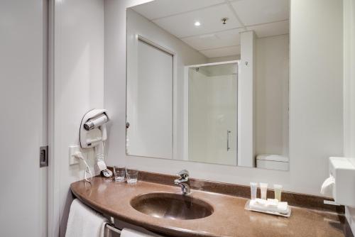 a bathroom with a sink and a large mirror at ibis Rotorua in Rotorua
