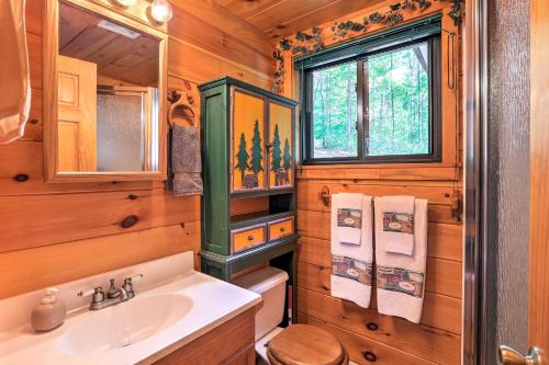 uma casa de banho com um lavatório, um WC e uma janela. em Hocking Hills Lake Gem with Hot Tub, Dock, 100 Acres em Hamden
