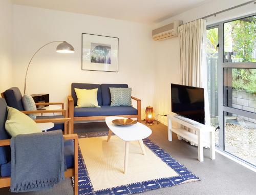 a living room with a blue couch and a tv at qTownPad in Queenstown
