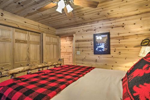 a bedroom with a checkered bed in a log cabin at Waterfront Pike Lake Retreat Snowmobile Paradise in Park Falls