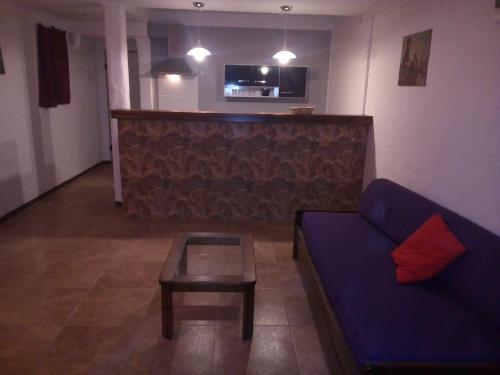 uma sala de estar com um sofá azul e uma mesa em PORTOFINO BARRIO COUNTRY em Piriápolis