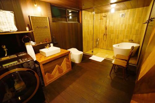 a bathroom with a sink and a shower and a toilet at HAKUBA LODGE OMUSUBI in Otari