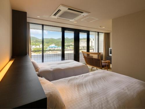 a hotel room with two beds and a large window at Shimahana in Sumoto