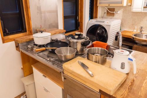 a kitchen counter with pots and pans on a stove at back alley residence Hibi in Osaka