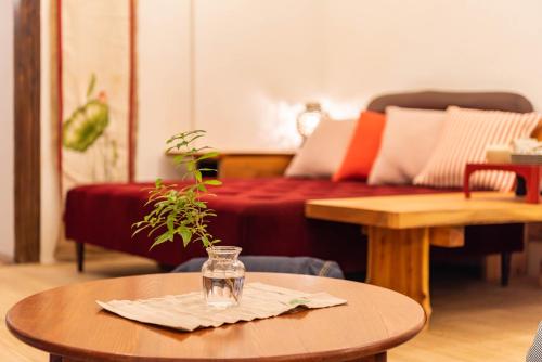 ein Wohnzimmer mit einem Tisch und einem Glas darauf in der Unterkunft back alley residence Hibi in Osaka