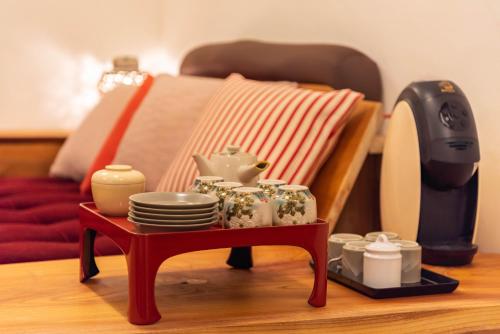 a table with a tea set and plates and a juicer at back alley residence Hibi in Osaka