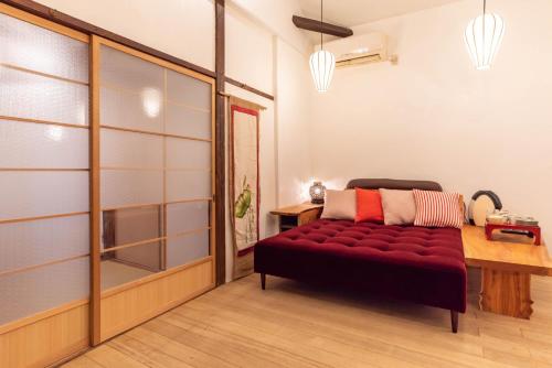 a bedroom with a red couch in a room at back alley residence Hibi in Osaka