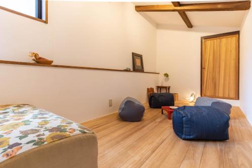 a bedroom with a bed and two blue chairs at back alley residence Hibi in Osaka