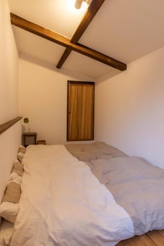 a large bed in a room with a wooden ceiling at back alley residence Hibi in Osaka