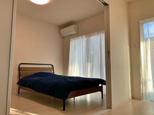 金武町にあるスノーボールコンドミニアムの鏡付きの部屋にベッド1台が備わるベッドルーム1室があります。