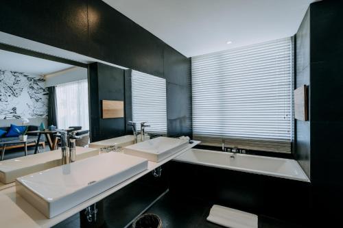 a bathroom with two sinks and a large mirror at ARTOTEL Sanur Bali in Sanur