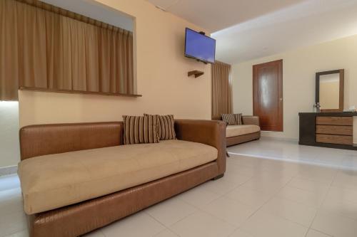a living room with a couch and a flat screen tv at Casa Shalom Puebla in Puebla