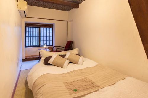 a bedroom with a bed and a window at back alley residence Hibi in Osaka