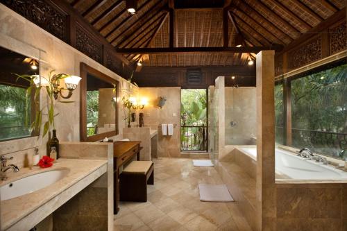 Ayung Resort Ubud في بيانغان: حمام مع مغسلتين وحوض استحمام