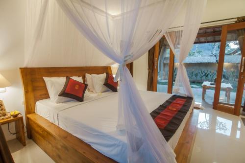 - une chambre avec un lit et une moustiquaire dans l'établissement Abimana Ubud, à Ubud