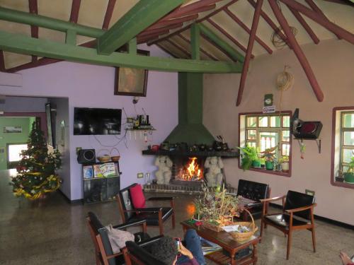 een woonkamer met een open haard in een huis bij Hotel Portón De Ocetá in Monguí